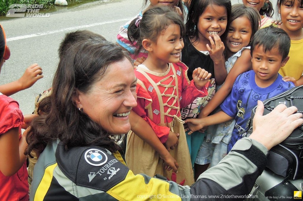 Women Who Ride: Lisa Thomas with a group of kids in Flores, Indonesia
