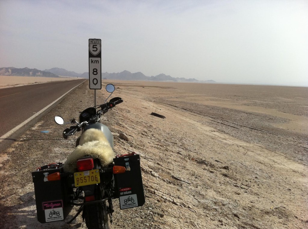 Women Who Ride: Stopped somewhere in Mexico. The image depicts a Yamaha XT225 stopped on the side of a road with a barren landscape and mountains in the distance.